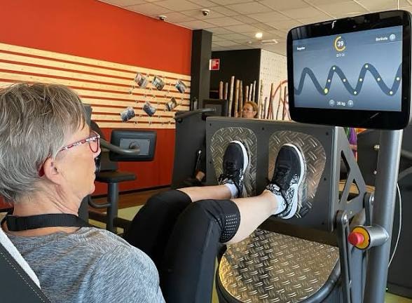 Oudere vrouw traint op de EGYM leg press